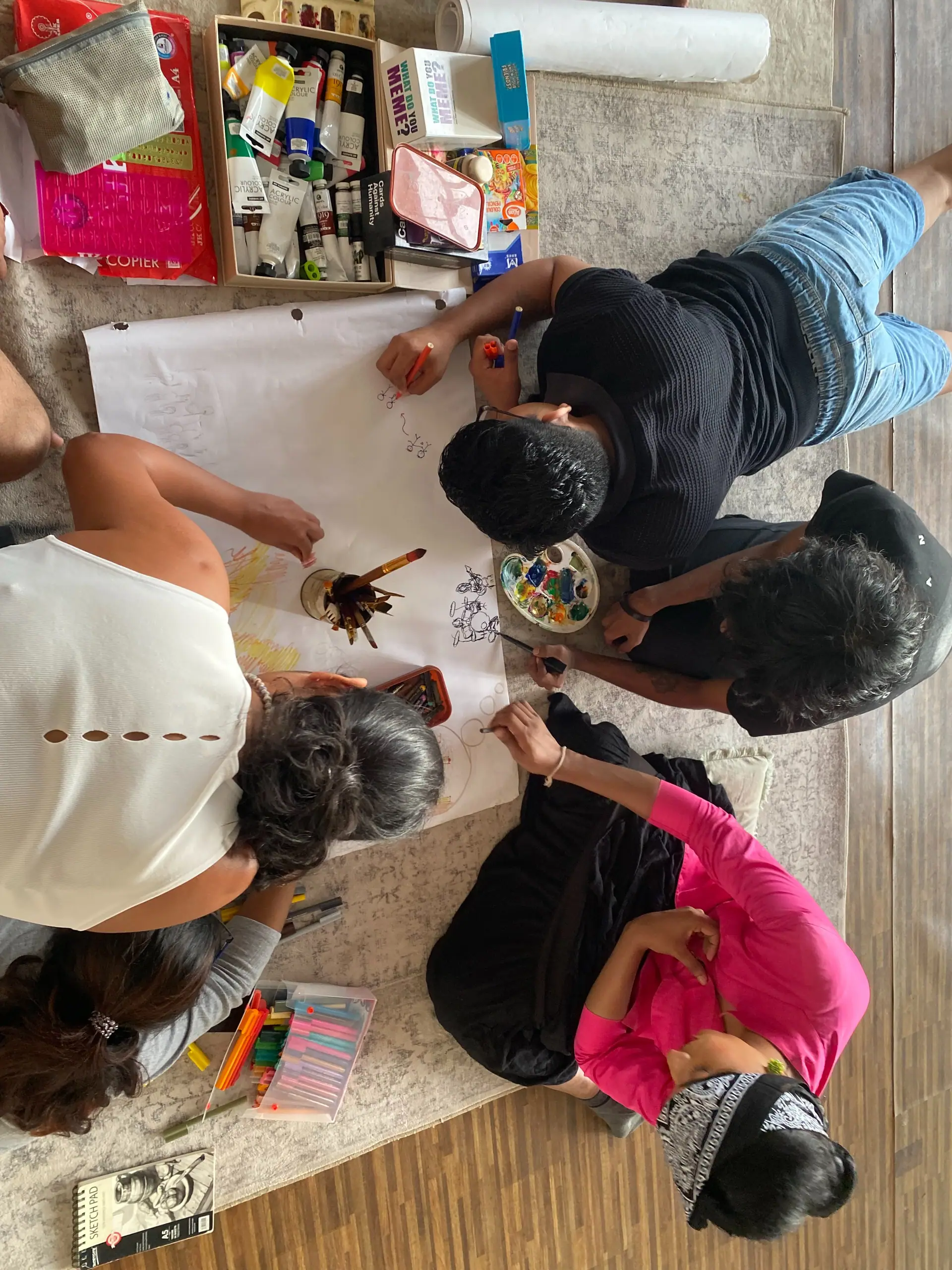 Art Clerb hangout — group painting on shared paper on the floor