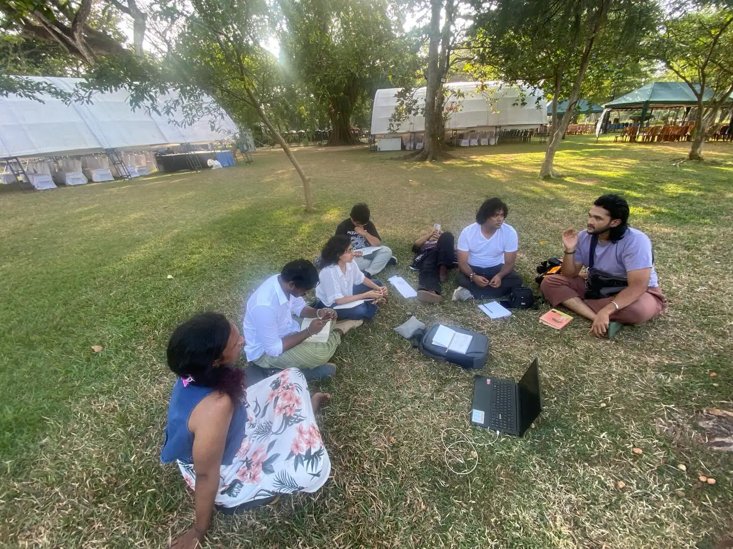 Art Clerb circle sketching outdoors on the grass